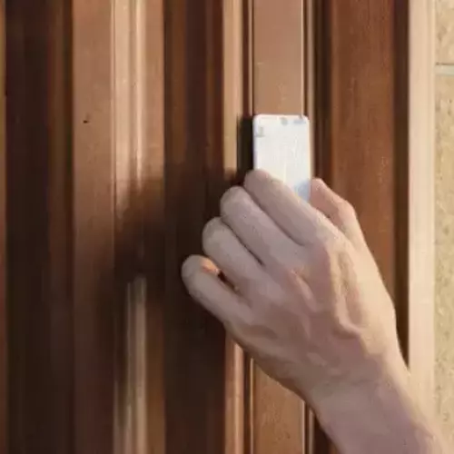a man installing intellibell at his front door